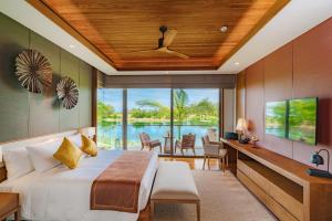 a bedroom with a bed and a view of the ocean at Aquella Lakeside Villas in Thai Muang