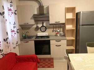 a small kitchen with a stove and a refrigerator at Mansarda Mentana due in Vittoria