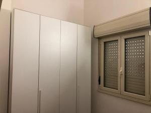 a bedroom with white cabinets and a window at Mansarda Mentana due in Vittoria