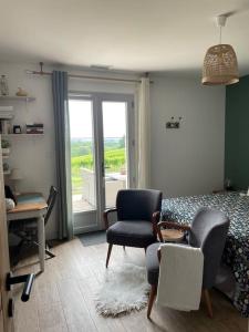 a bedroom with a bed and a chair and a desk at Le nid du vallon in Pomport