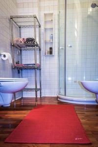 - une salle de bains avec un tapis rouge à côté d'un lavabo et d'une douche dans l'établissement Art District Loft Venice, à Venise