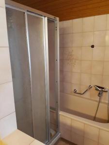 a shower with a glass door in a bathroom at Zimmer im Berghaus für Backpaking - Das gemütliche Haus des Grossvaters - Bergheimat - Ganz einfach - ganz unkompliziert - ganz relaxd in Linthal