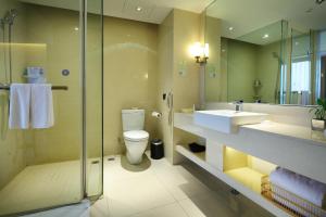 ein Badezimmer mit Toilette, Waschbecken und Dusche in der Unterkunft Wudang International Hotel in Shiyan