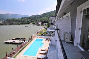 een balkon met een zwembad naast een rivier bij Serenity in Eşelniţa