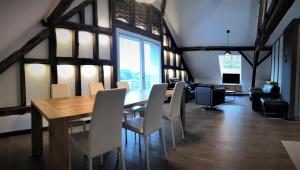 - une salle à manger avec une table et des chaises en bois dans l'établissement POSTRELAIS ARDENNES "Belle-Vue", à Burg-Reuland