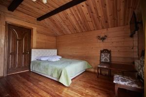 1 dormitorio con 1 cama en una habitación de madera en Садиба у Кіри en Slavske