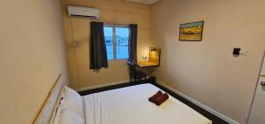 um pequeno quarto com 2 camas e uma janela em Starry night homestay em Kota Kinabalu
