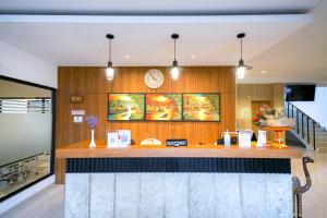 a kitchen with a bar with a clock on the wall at Urbanview Pecatu Residence Bali by RedDoorz in Ungasan