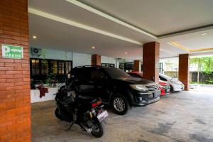 a garage with a motorcycle and a car parked in it at Urbanview Pecatu Residence Bali by RedDoorz in Ungasan