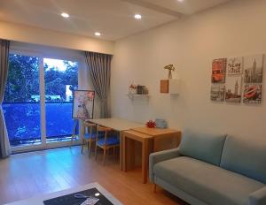 een woonkamer met een tafel en een bank bij ICASA Serviced Apartment in Ho Chi Minh-stad