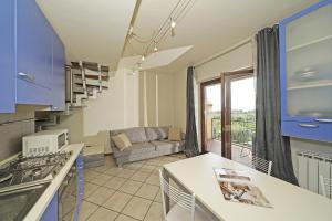 cocina con armarios azules y sala de estar. en Borgo Alto P1-16 by Wonderful Italy, en Puegnago sul Garda
