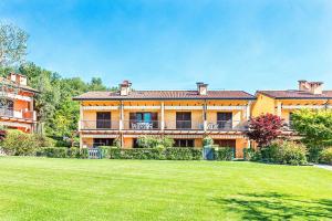 una gran casa amarilla con un gran patio en Borgo Alto P1-16 by Wonderful Italy, en Puegnago sul Garda