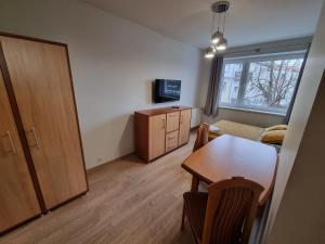 Il comprend un petit salon avec une table et une cuisine. dans l'établissement Apartament Olszewskiego, à Wrocław