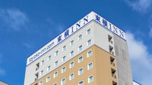 a building with a sign on top of it at Toyoko Inn Nagoya Kanayama in Nagoya