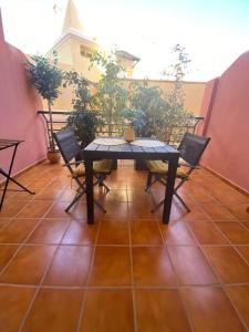 uma mesa e cadeiras sentadas num terraço com uma mesa e cadeiras em Costa del Golf em Torre de Benagalbón