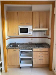 una piccola cucina con lavello e microonde di Costa del Golf a Torre de Benagalbón