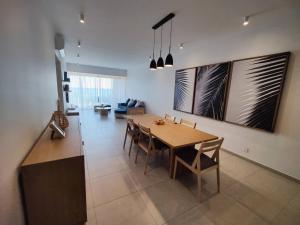 Ocean Point Beach Front Apartment في بوينتي أو بيتشيز: غرفة طعام مع طاولة وكراسي خشبية