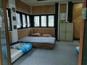 1 dormitorio con 2 camas en una habitación con ventanas en Roemah Abdoe, en Arau