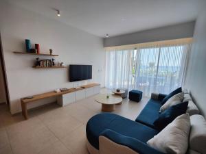 sala de estar con sofá azul y mesa en Ocean Point Beach Front Apartment, en Pointe aux Piments