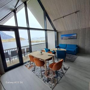 ヘニングスヴァールにあるBryggeleilighet i Henningsværのテーブルと椅子が備わる客室で、海の景色を望めます。