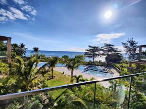 uma vista para o oceano a partir da varanda de um resort em Ocean Point Beach Front Apartment em Pointe aux Piments