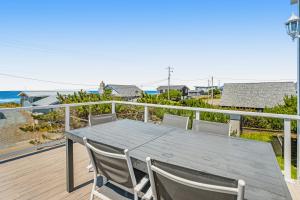 Una mesa y sillas en una terraza con vista al mar. en The Whaler, en Rockaway Beach