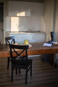 eine Küche mit einem Holztisch und einem schwarzen Stuhl in der Unterkunft Houten huisje tussen paarden in Nieuwerkerken
