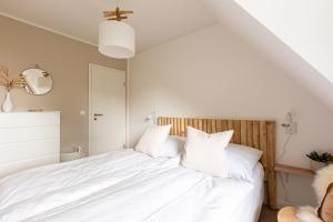 a bedroom with a white bed with white pillows at Schöne Aussichten in Wieck