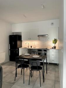 eine Küche mit einem schwarzen Tisch und Stühlen in der Unterkunft Maison 90m2 Lormont 3 chambres et jardin in Lormont