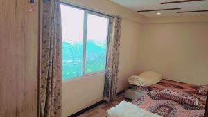 a bedroom with a bed and a large window at Diamond view apparments in Bāriān