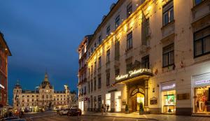 Palais-Hotel Erzherzog Johann في غراتس: شارع المدينة بالليل فيه مباني والناس