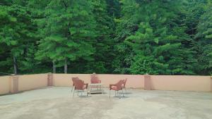 three chairs and a table in front of a fence at Diamond view apparments in Bāriān
