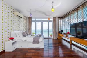a bedroom with a white bed and a flat screen tv at Palm Villa 23 (Beachfront Pool Villa Vung Tau with an Ocean view and Karaoke, Billards) in Vung Tau