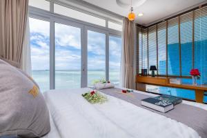 a bedroom with a bed with a view of the ocean at Palm Villa 23 (Beachfront Pool Villa Vung Tau with an Ocean view and Karaoke, Billards) in Vung Tau