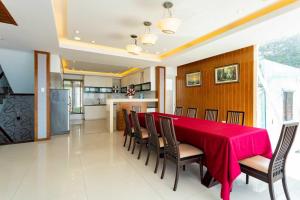 a dining room with a red table and chairs at Palm Villa 23 (Beachfront Pool Villa Vung Tau with an Ocean view and Karaoke, Billards) in Vung Tau