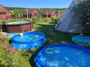two blue trays in the grass next to a tent at Siedlisko Carownica Family & Wellness in Lechów