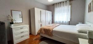 a bedroom with a bed and a dresser and a window at Renovated apartment, center and hospital in Udine