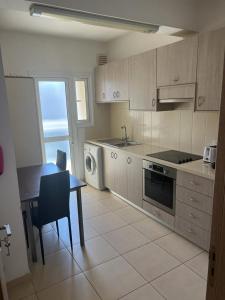 a kitchen with a table and a sink and a stove at Takelena Apartments in Limassol