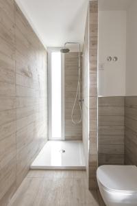 a bathroom with a shower and a toilet and a window at ISA-Residence with swimming-pool in Stintino near the famous La Pelosa-beach in Stintino