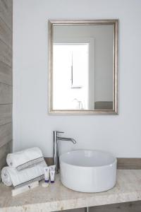 a white bathroom with a sink and a mirror at ISA-Residence with swimming-pool in Stintino near the famous La Pelosa-beach in Stintino