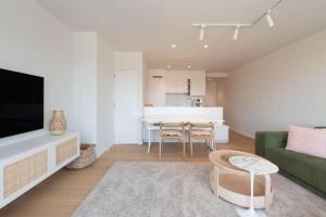 un salon avec un canapé vert et une table dans l'établissement Panne-O-Rama, à La Panne 7 autres photos