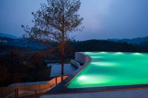 a swimming pool with a tree in the middle at Erzhuo Valley in Furong Town - Among the Clouds 