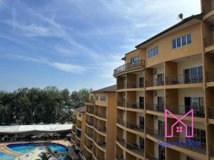 een groot appartementencomplex met een zwembad en een roze x bij Gold Coast Morib Resort in Banting