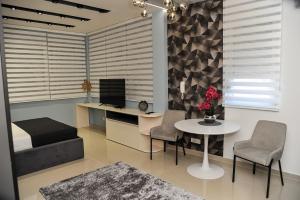 a bedroom with a bed and a table and chairs at Premium apartmani Petica in Valjevo