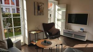 a living room with a chair and a television at Stella Maris in Norden