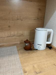 a coffee maker on a wooden counter next to a tea pot at Аэропорт 5 минут in Prigorodnyy