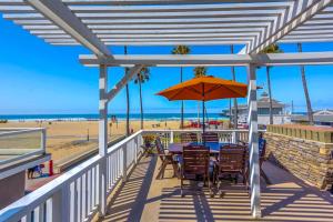a patio with a table and an umbrella on the beach at Newport Vacation Memories in Newport Beach