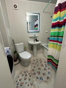 a bathroom with a toilet and a sink and a mirror at Аэропорт 5 минут in Prigorodnyy