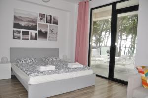 sypialnia z łóżkiem i przesuwnymi szklanymi drzwiami w obiekcie Apartmany Paradiso Shekvetili w mieście Shekhvetili