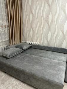 un letto con due cuscini sopra in una stanza di Аэропорт 5 минут a Prigorodnyy